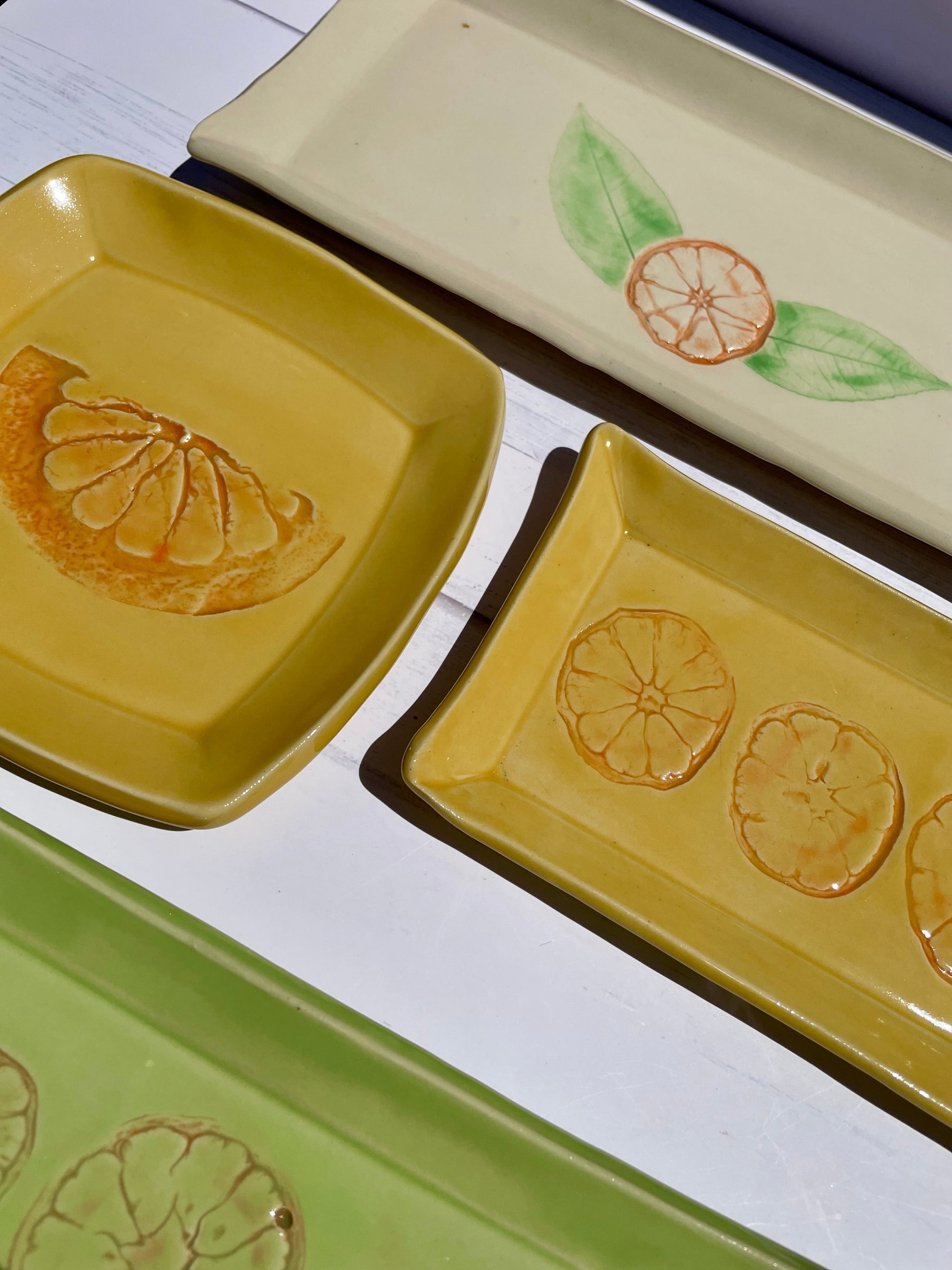 Set of ceramic trays with lemon designs on a white surface